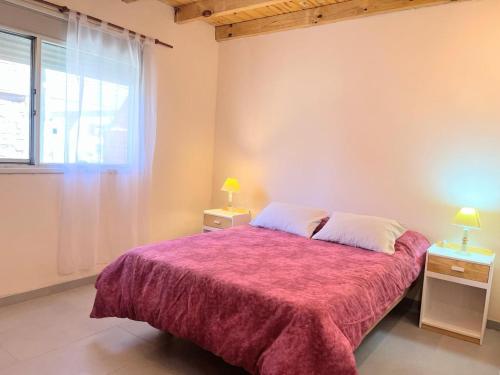 a bedroom with a large bed with a red blanket at Village Pehuen in Balneario Pehuén-Có