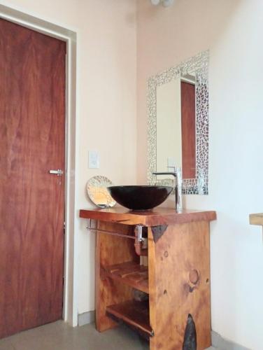 a bathroom with a wooden sink and a mirror at Village Pehuen in Balneario Pehuén-Có