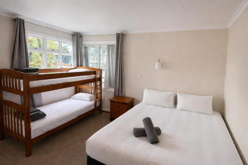 a bedroom with two bunk beds and a window at Havelock North Holiday Park in Havelock North