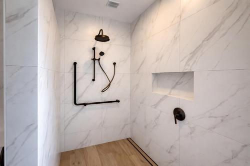 a bathroom with a shower with white marble walls at Havelock North Holiday Park in Havelock North