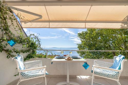 two chairs and a table on a patio with a view of the ocean at Libera1 in Stara Baška