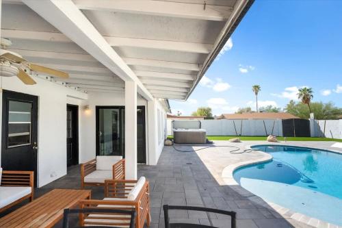a patio with a pool and chairs and a house at Rock and Glam Paradise in Mesa