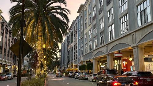 a city street with a palm tree and buildings at Santana Row Garden Retreat Private Executive Residence with Koi Pond and Waterfall Walk to Santana Row Valley Fair Dining and Shopping Private Entrance in San Jose