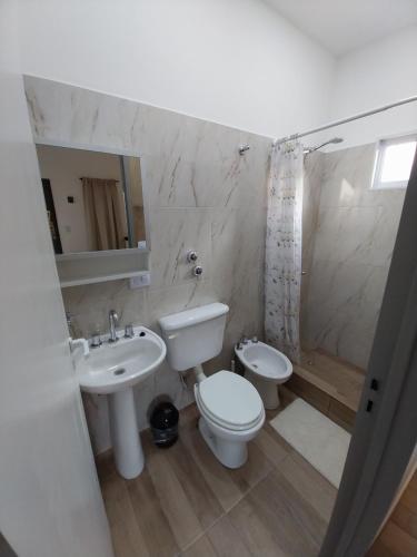 a bathroom with a sink and a toilet and a shower at Dormi km3 in Comodoro Rivadavia