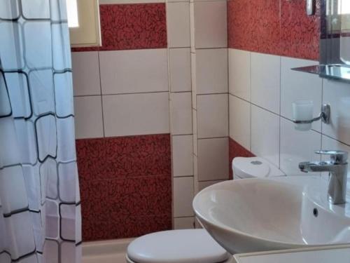 a bathroom with a white sink and a toilet at Pinkapartment Saranda in Sarandë
