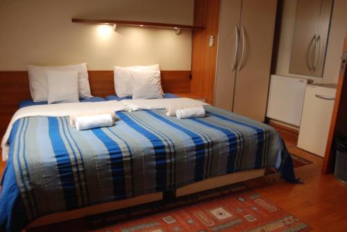 a bedroom with a large bed with towels on it at Car Royal Apartments and Rooms in Novi Sad