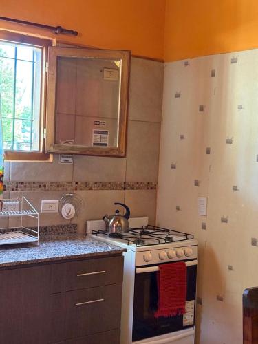 a kitchen with a stove and a tea kettle at Los Pinos in El Bolsón