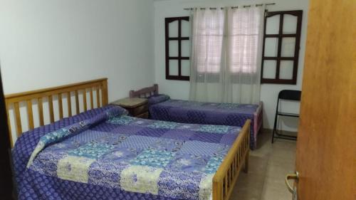a bedroom with two beds and a window at Casa Aurora 1 Cosquín in Cosquín