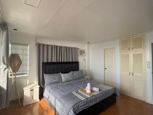 a bedroom with a bed with two pink shoes on it at Bobby's Villa Beachfront, Paringao, La Union in Bauang