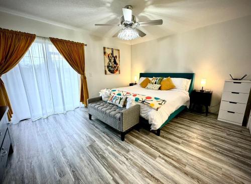 a bedroom with a bed and a couch and a ceiling fan at Mid-Century Modern Beachfront in Flagler Beach