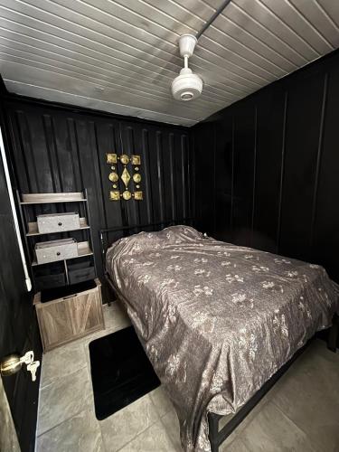 a bedroom with a bed in a room with black walls at Villa Sonia in Caldera