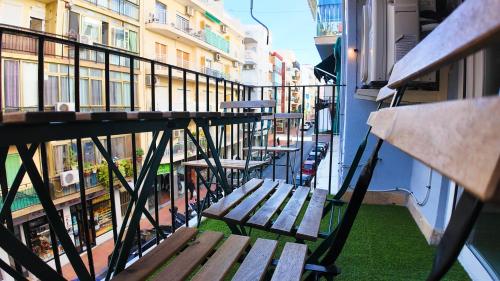 a balcony with wooden benches on a building at Apartalux Benidorm's Port in Benidorm