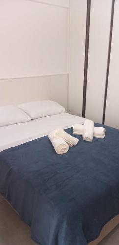 a bed with two towels and two pillows on it at Apartamento Studio in Barbacena