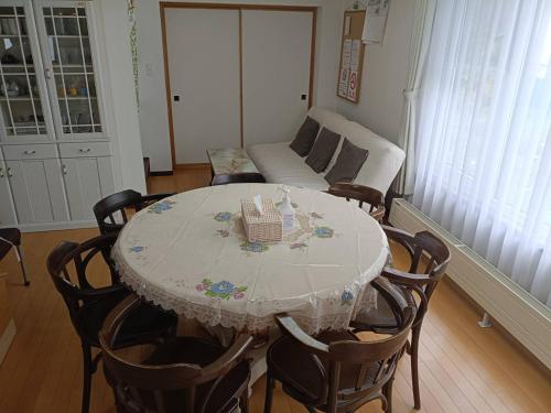 a dining room table and chairs with a table and a couch at DOWNTOWN　TOKO11 in Asahikawa