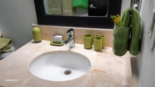 a bathroom sink with two cups and a mirror at Citnos Luxury Accommodation in Telchac Puerto