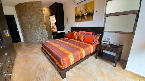 a bedroom with a bed with a table and a mirror at Citnos Luxury Accommodation in Telchac Puerto