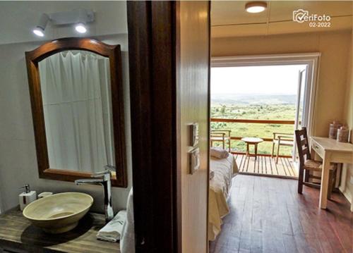 a bathroom with a sink and a view of a balcony at El Abrazo de las Sierras in Minas