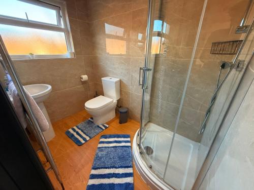a bathroom with a toilet and a glass shower at Tarleton house in Stoke on Trent