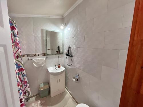 a white bathroom with a sink and a toilet at Hospedaje Brisas de Frutillar in Frutillar