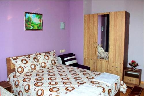 a bedroom with a bed and a chair in it at Къщи за гости Илиеви , Цигов Чарк in Batak