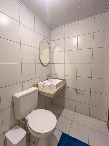 a white bathroom with a toilet and a sink at Casa Mar e Rio Milagres in São Miguel dos Milagres