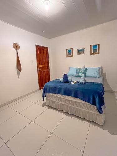 a bedroom with a bed with a blue blanket at Casa Mar e Rio Milagres in São Miguel dos Milagres