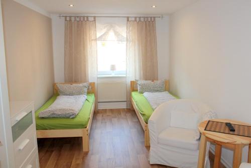 a small room with two beds and a window at Doppelzimmer - Monteurswohnung - Arbeiterwohnung 4-8 Personen in Plaue