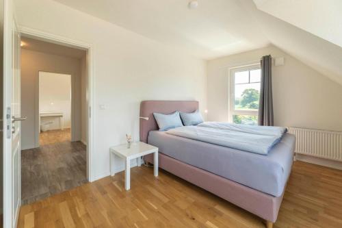 a bedroom with a bed and a table in it at Ferienhaus-Belvedere-2-c in Blekendorf