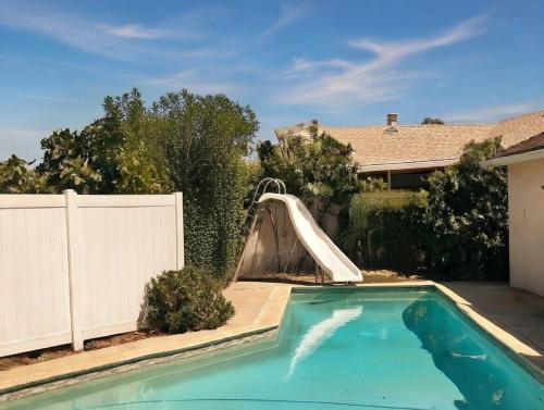 a swimming pool with a slide in a backyard at A Bridge to All San Diego Central Pool Home Private Room in San Diego