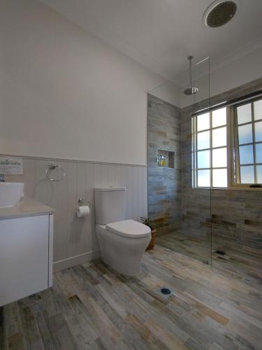 a bathroom with a toilet and a sink and a shower at Canyonleigh Retreat in Canyonleigh