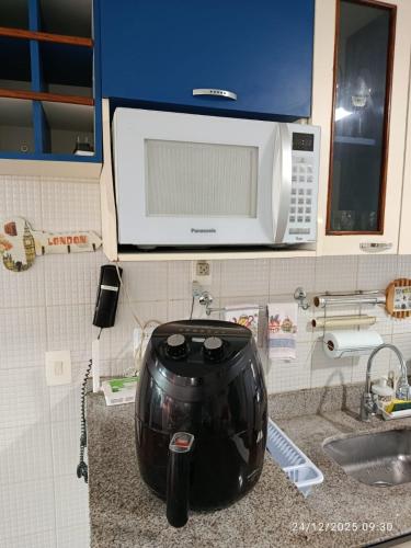 a kitchen counter with a blender on a counter top with a microwave at Flat 207 Villa Hípica - Gravatá in Gravatá