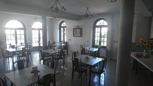 a dining room with tables and chairs and windows at Dworek Mitro in Gdynia