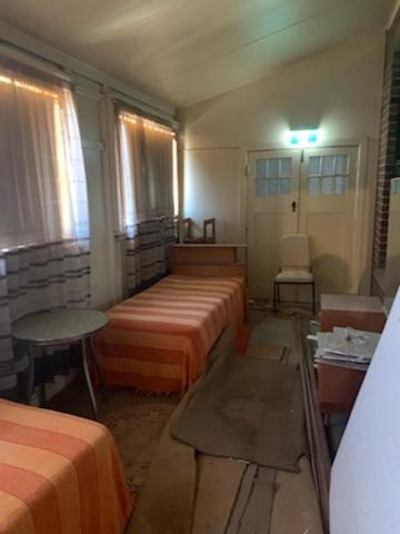 a room with two beds and a table in it at Commercial Hotel in Birchip