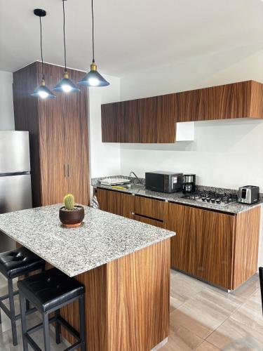 a kitchen with wooden cabinets and a counter top at Cabo Marino Apartment, Pool, Beach and Marina in Conchal