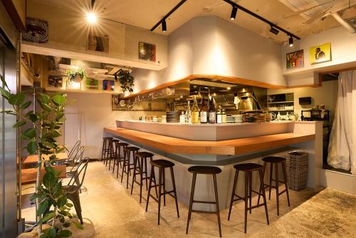 a bar in a restaurant with stools at a counter at Dogen sauna&stay in Tokyo
