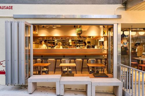 a restaurant with a bar with tables and chairs at Dogen sauna&stay in Tokyo
