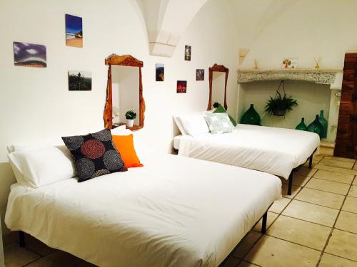 マルティナ・フランカにあるB&B Palazzo Giorgiのベッド2台(白いシーツ付)