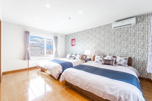 a bedroom with two beds and a window at THE WORLDWIDE HOUSE in Sapporo