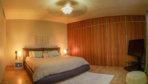 a bedroom with a large bed and a flat screen tv at Casa Prisma amplitud y privacidad in Chihuahua