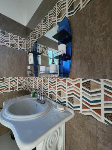 a bathroom with a sink and a mirror at Palm Breeze Villa in Green Island