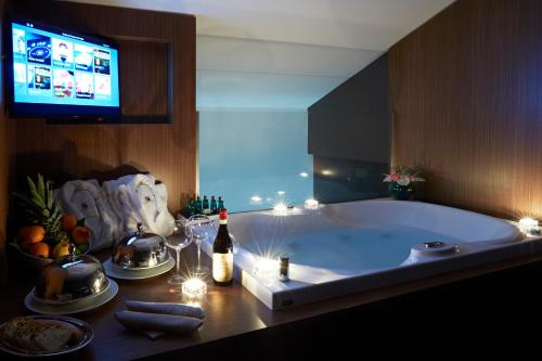 eine Badewanne mit einer Flasche Wein und einen TV in der Unterkunft Hotel The Building in Rom