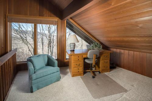 an attic office with a desk and a chair at The Buc's Den in Beech Mountain