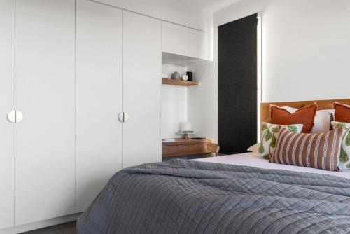 a bedroom with a bed and white cabinets at The Ridge at Maleny Deluxe Residence - Panoramic Valley Views in Maleny