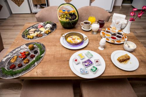 a wooden table with plates of food on it at Bilge Suite Hotel in Corum