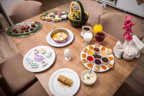 a table with plates of food and drinks on it at Bilge Suite Hotel in Corum