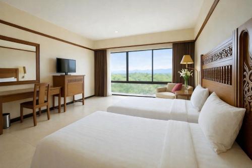 a hotel room with a bed and a desk and a computer at Loei Palace Hotel in Loei