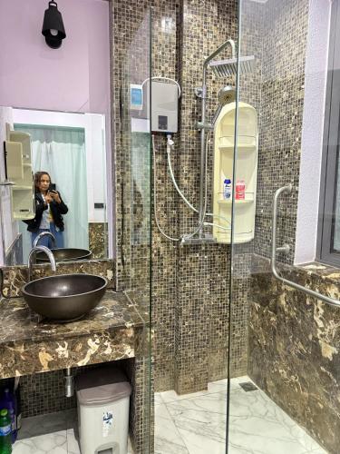 a woman taking a picture of a bathroom with a sink at เกาะช้าง พูลวิลล่า วิวทะเล 2 in Trat