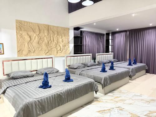 three beds in a room with blue hats on them at เกาะช้าง พูลวิลล่า วิวทะเล 2 in Trat