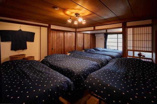 a bedroom with four beds in a room with wooden walls at Hinosawa Riverside Lodge 水遊び宿日野沢 in Minano