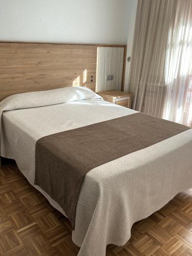 ein großes Bett in einem Schlafzimmer mit Holzboden in der Unterkunft Hotel Can-Vic in Guadalajara